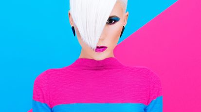 Fashion blond model with trendy hairstyle on a colorful background. Art photo